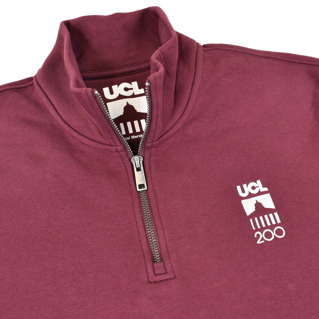 Close up on collar burgundy quarter zip with UCL 200 logo on chest 
